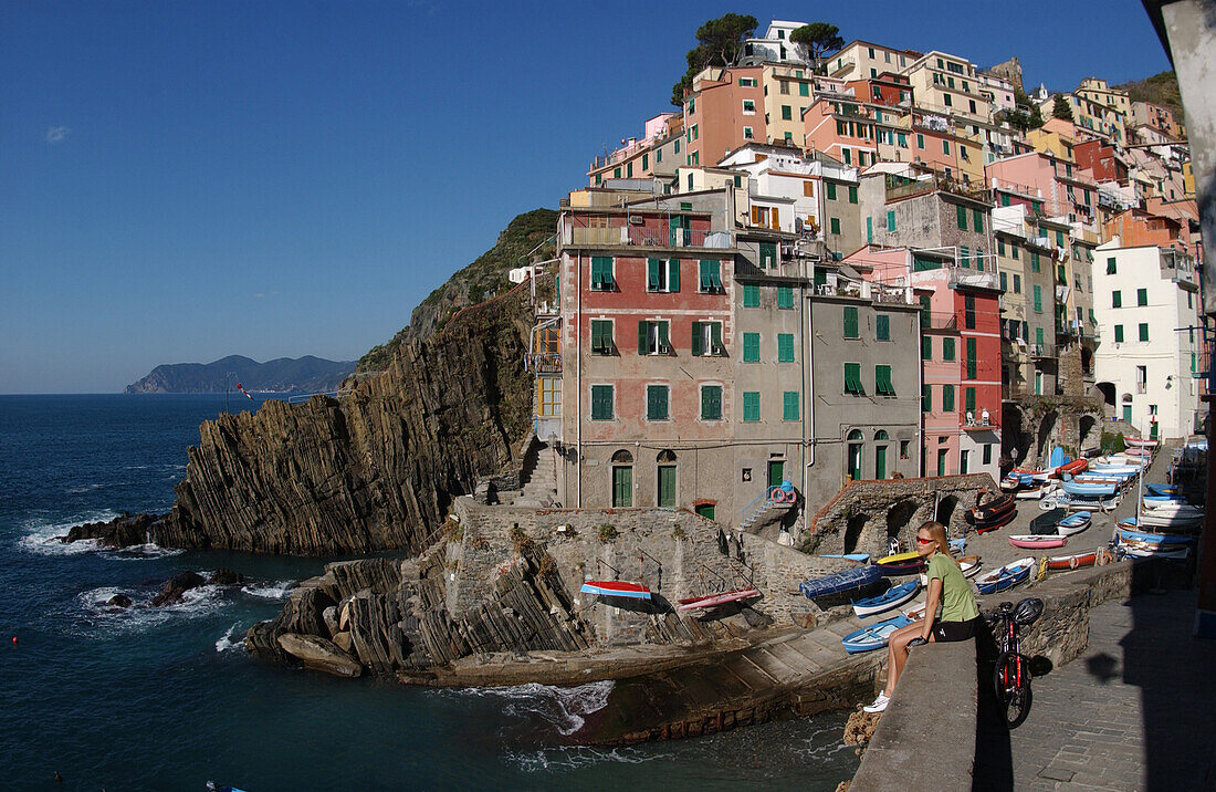 A woman enjoying a break at the harbour, Riomaggiore, Cinque Terre, Italy