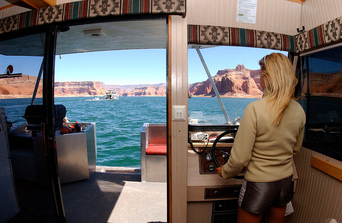 Eine Frau fährt ein Boot, Lake Powell, Arizona, Utah, USA