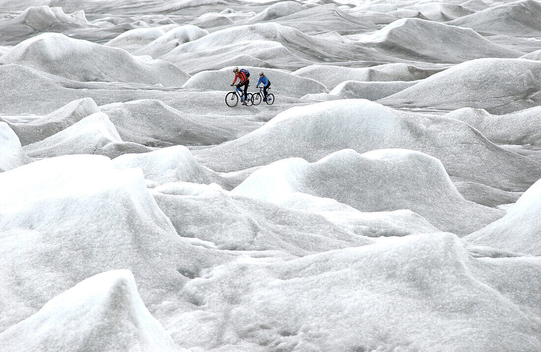 Two people mountainbiking over inland ice, Ilulissat, Inland ice Kangerlussuaq, Greenland