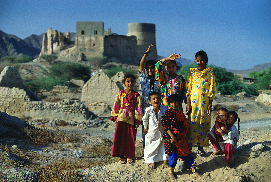 Children in front of Fujairah Fort in the sunlight, Fujairah, Middle East, United Arab Emirates, Asia