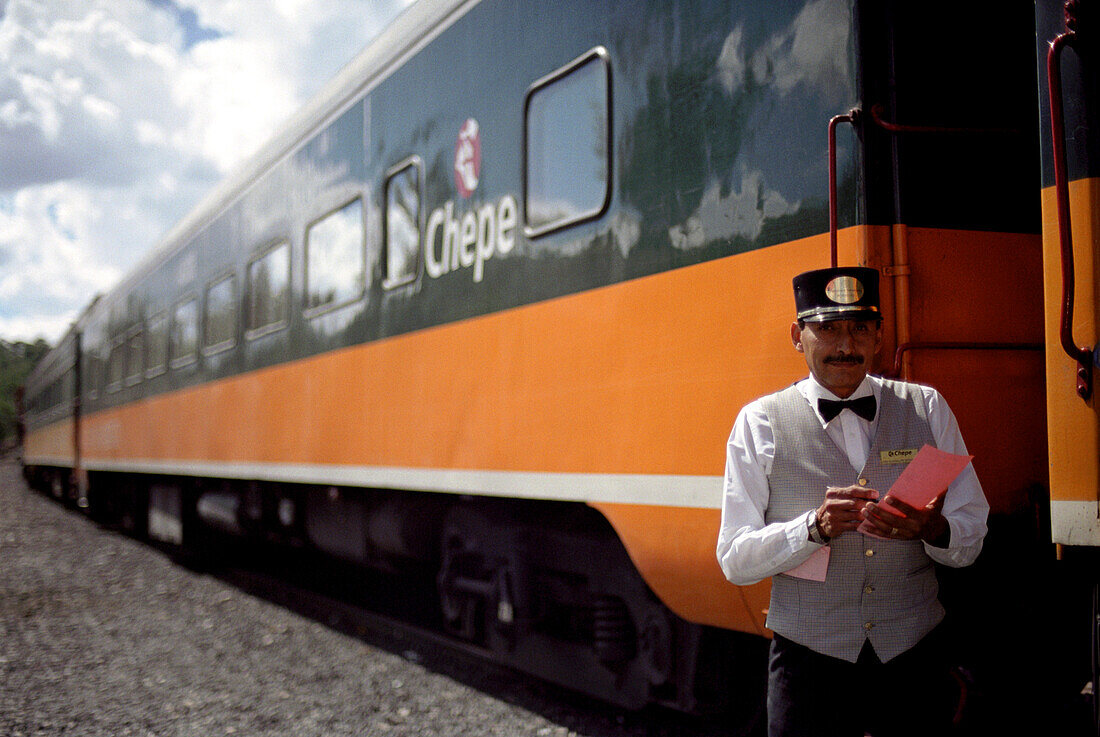 Ein Schaffner steht vor einem Zug, Ferrocarril Chihuahua al Pacifico, Chihuahua Express, Mexiko, Amerika