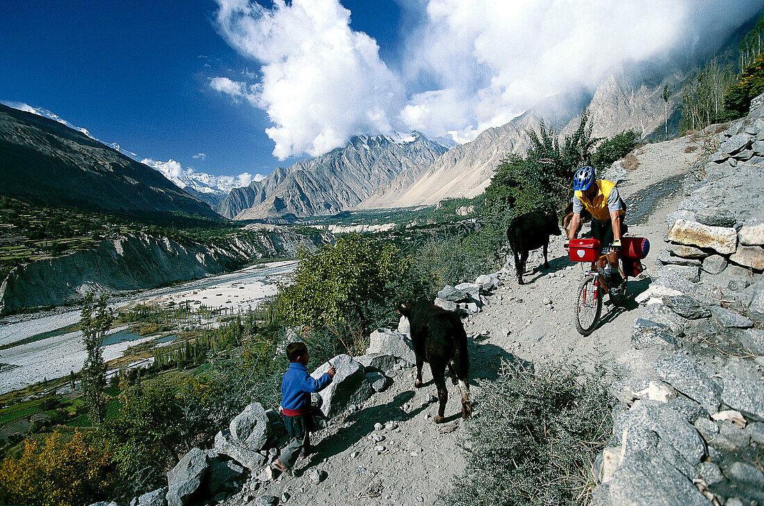 Mountainbiker und Hirtenjunge in den Bergen, Karakorum Highway, Hunza Tal, Pakistan