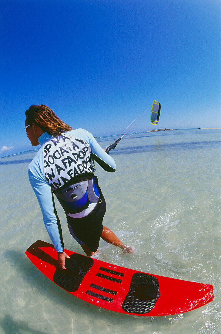 Young man with kiteboarding gear, ready for start