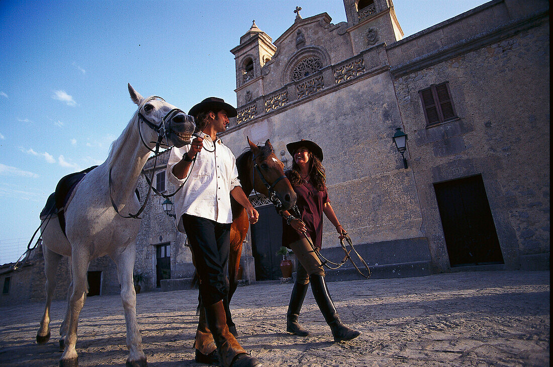 Ein Paar führt zwei Pferde, Mallorca, Spanien, Europa