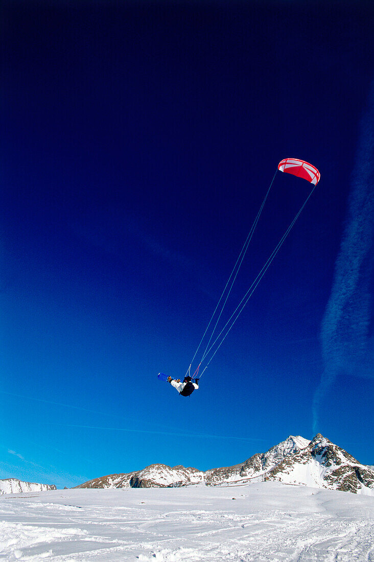 Man kiteboarding in snow, Jump, Lermoos, Lechtaler Alpen, Tyrol, Austria