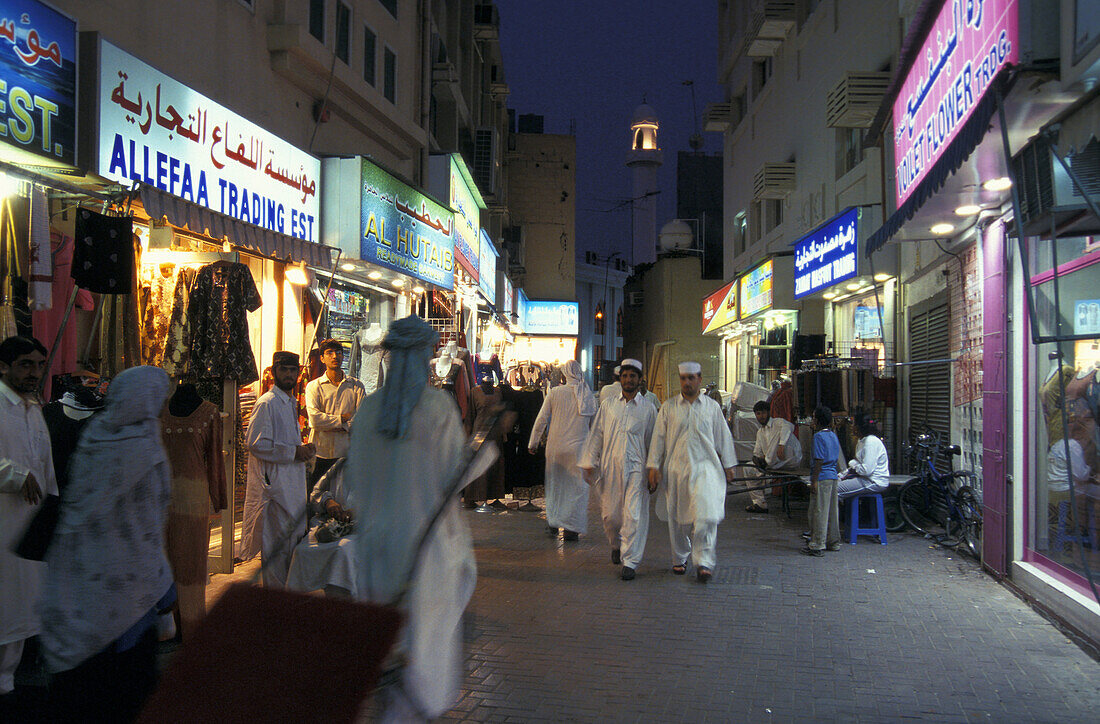 Menschen gehen am Abend durch eine Geschäftsstrasse, Souk, Dubai, Vereinigte Arabische Emirate