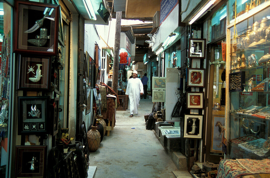 Mann geht durch eine Gasse zwischen Geschäften, Souk, Maskat, Oman