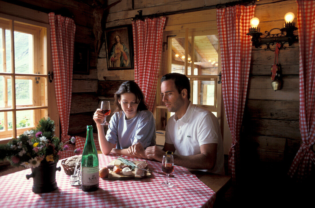 Couple having a meal in an alpine hut, South Tyrol, Italy, Europe