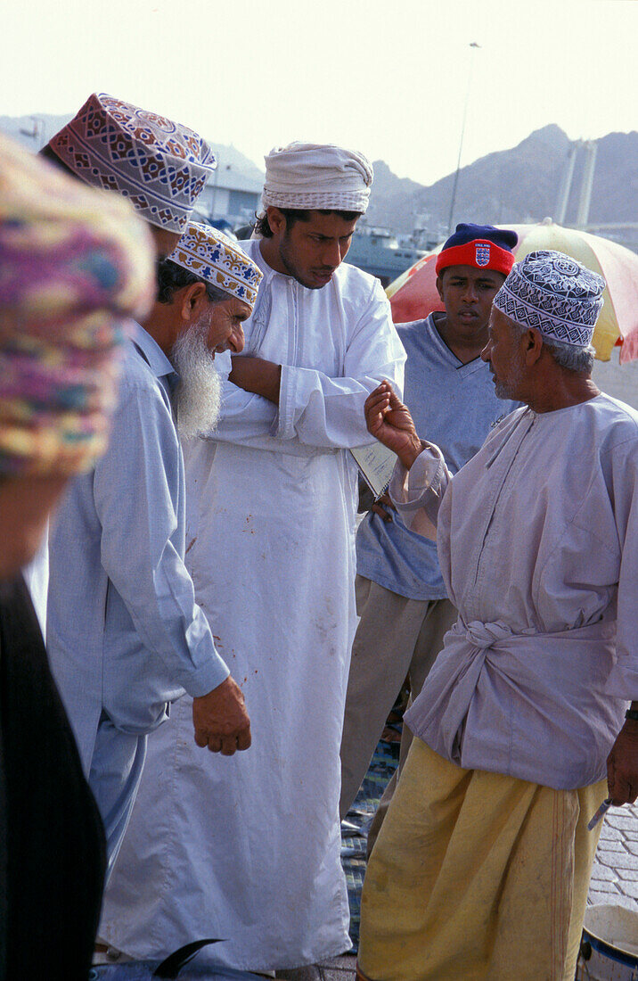 Men discussing at the harbour, Muscat, Oman, Middle East, Asia