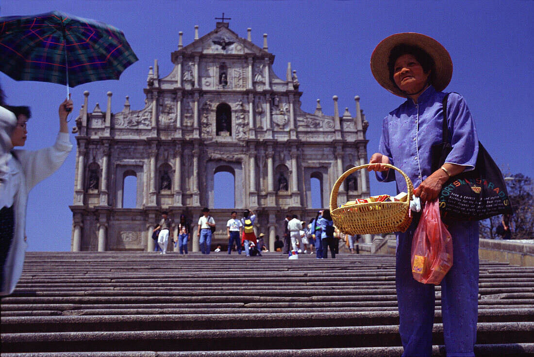 Vendor in front of Sao Paulo cathedral under blue sky, Macao, China, Asia