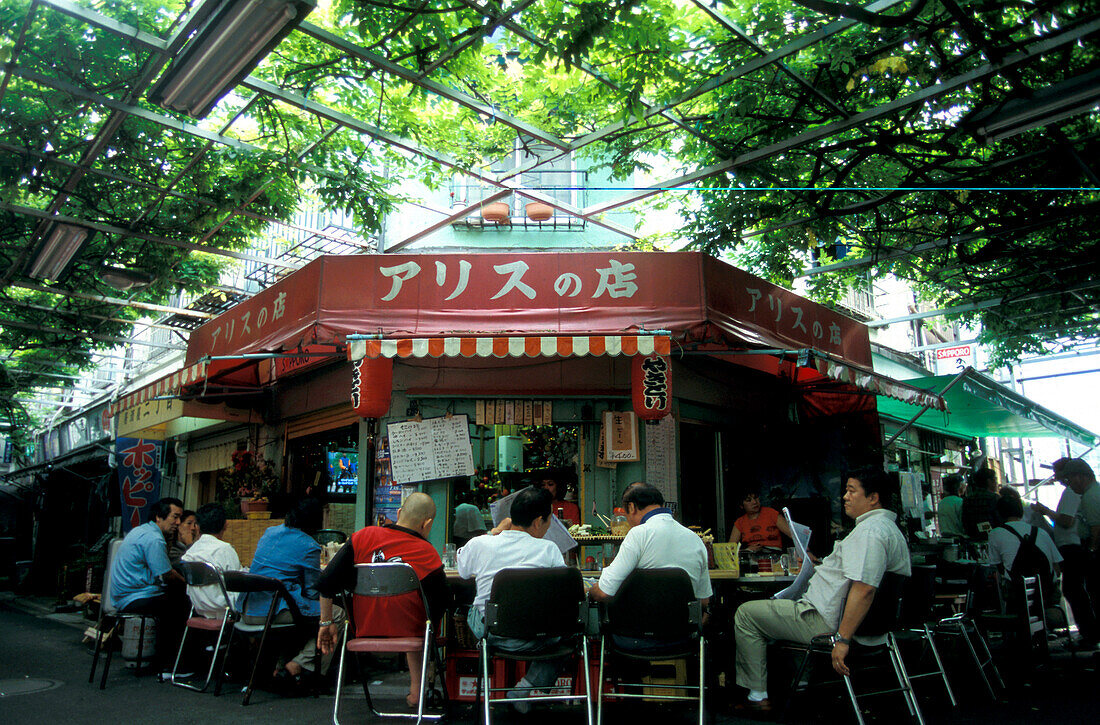 People sitting around a little local at Asakuza, Tokyo, Japan