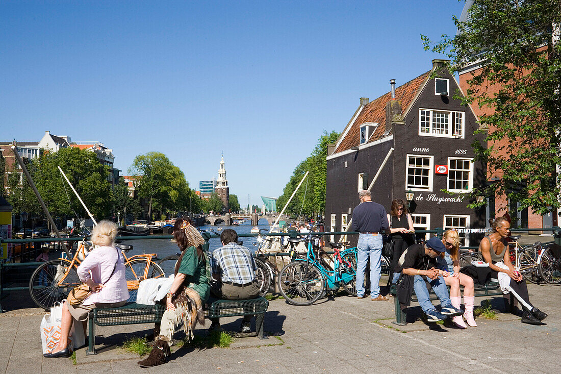 People, de Sluyswacht, Oude Schans, People sitting on bridge in the near of de Sluyswacht, a typical brown cafe at canal Oude Schans, Amsterdam, Holland, Netherlands