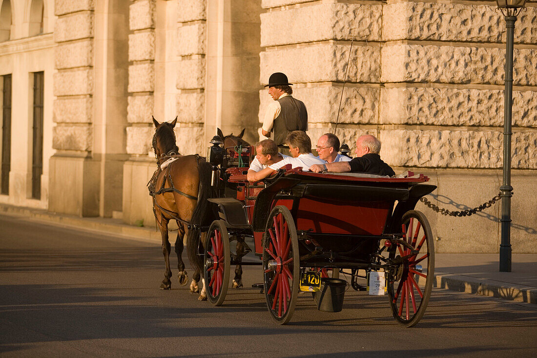 Fiaker passsing Neue Hofburg during a city tour, Vienna, Austria