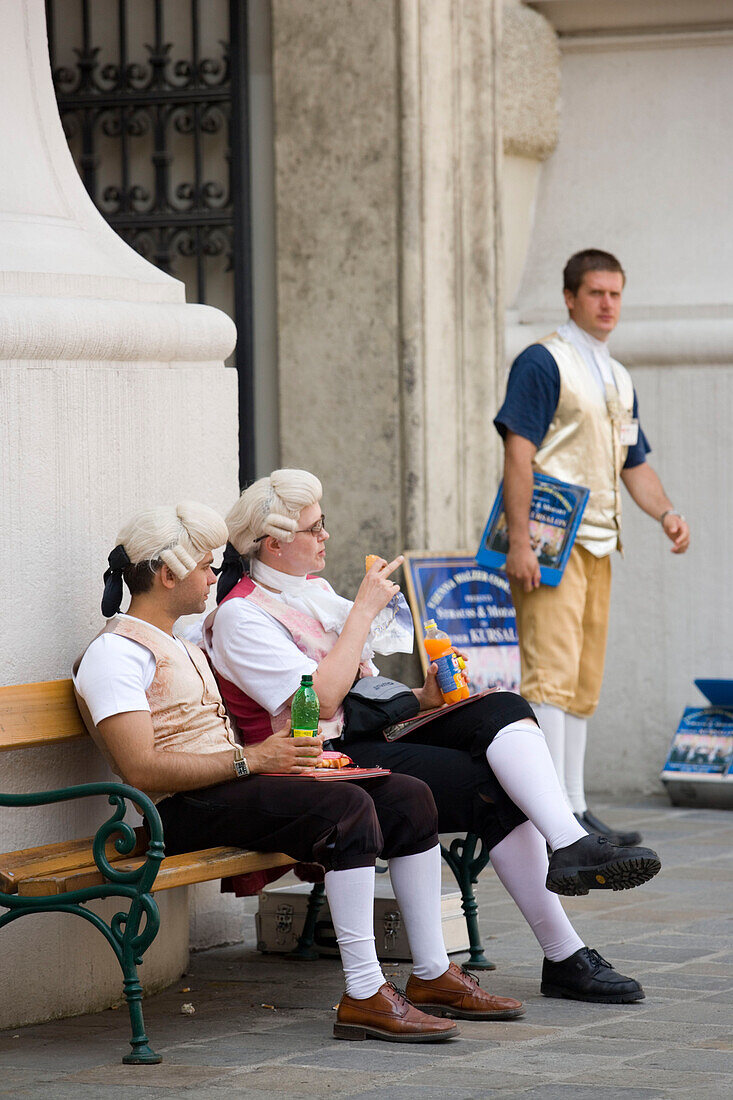 Men wearing mozart costumes selling programme for a classical concert, Hofburg, Vienna, Austria