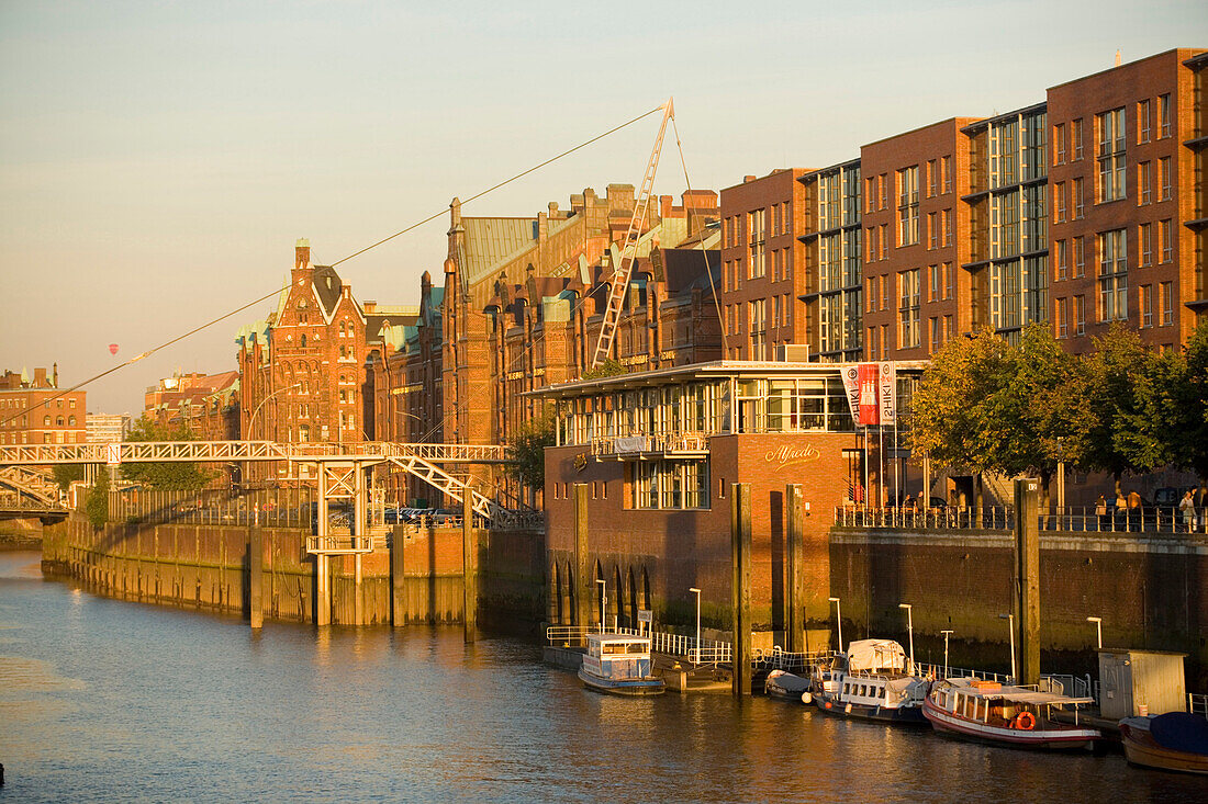 Blick auf eine Reihe von Backsteingebäuden der Speicherstadt im Sonnenlicht, Hamburg, Deutschland