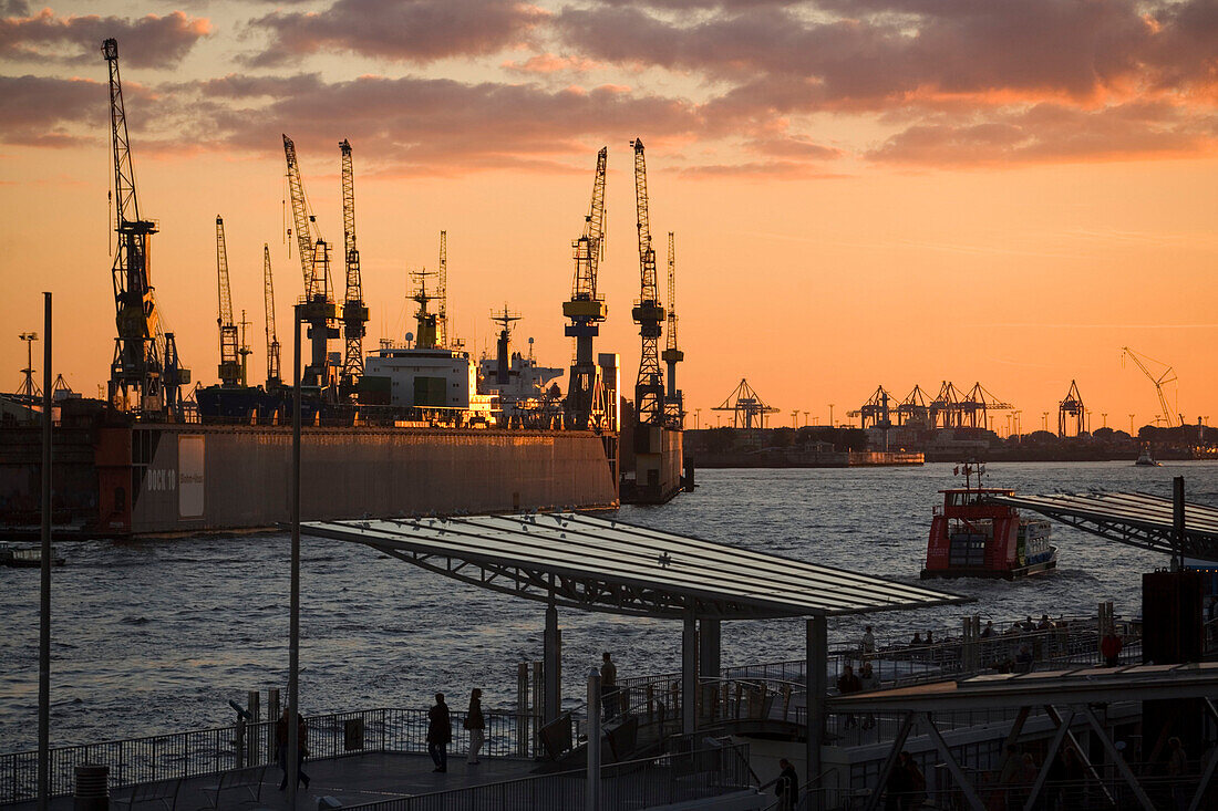 St. Pauli Landungsbruecken and cranes in background, View over tower at Landungsbruecken to dockyard with cranes in the dusk, Sankt Pauli, Hamburg, Germany