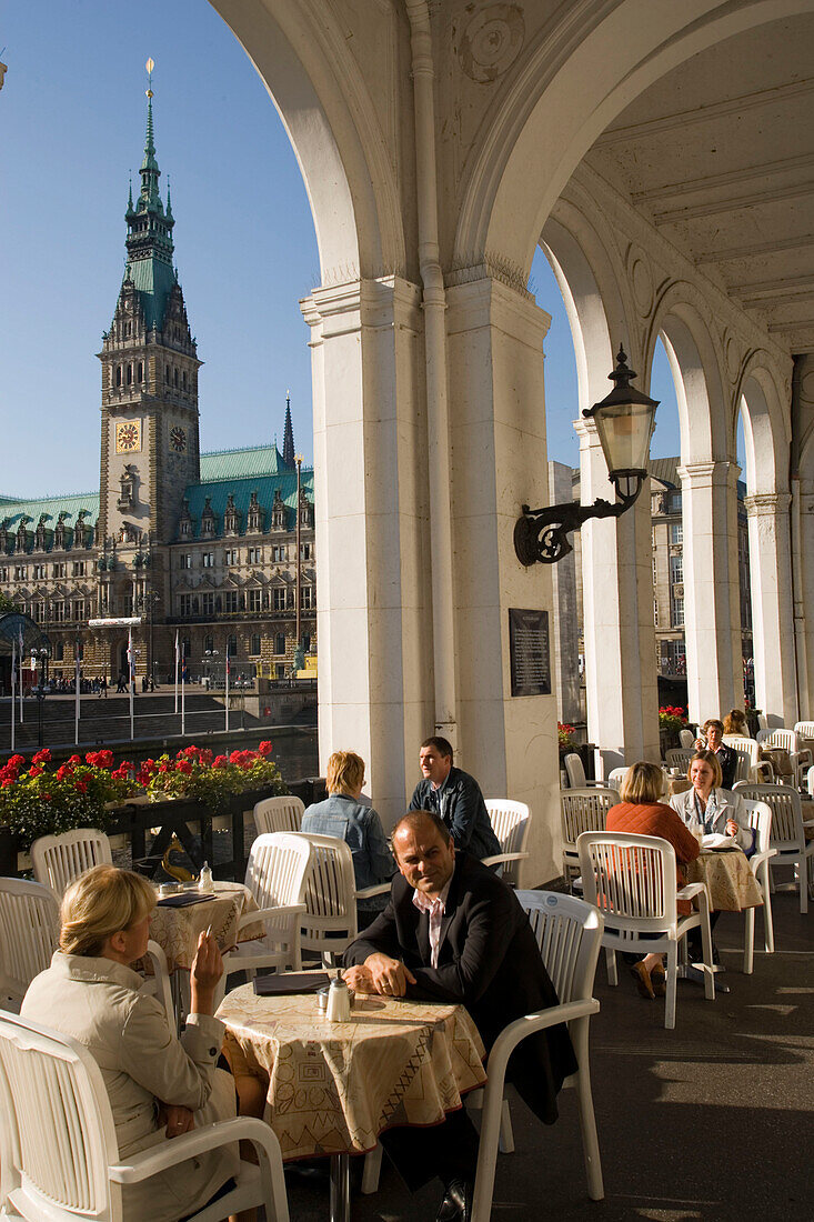 People at Alsterarkaden and view to the guildhall, People sitting in an open-air cafe at Alsterarkaden with view to the guildhall, Hamburg, Germany