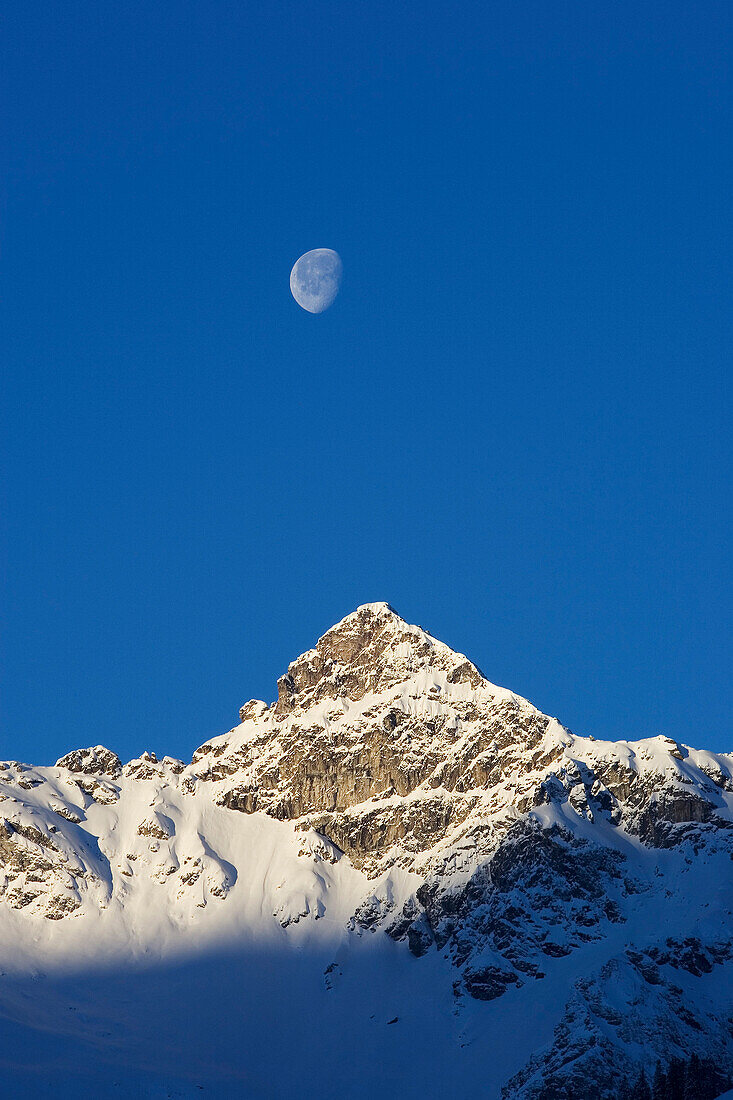 Früh am Morgen, Mond über verschneitem Berggipfel, Berglihorn, Glarner Alpen, Glarus, Schweiz