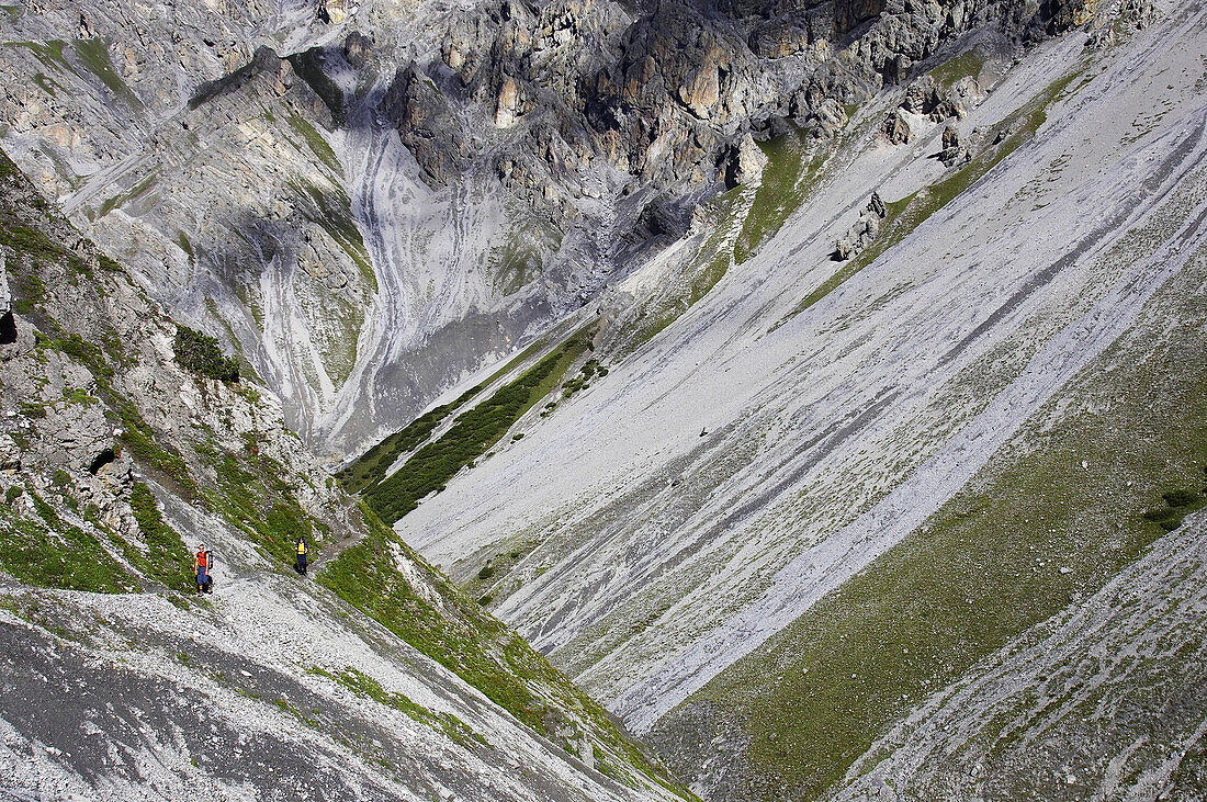 Zwei Wanderer auf einem wilden Bergwanderweg, Val Müschauns, Mueschauns, Fuorcla Val Sassa, Schweizerischer Nationalpark, Engadin, Graubünden, Graubuenden, Schweiz, Alpen