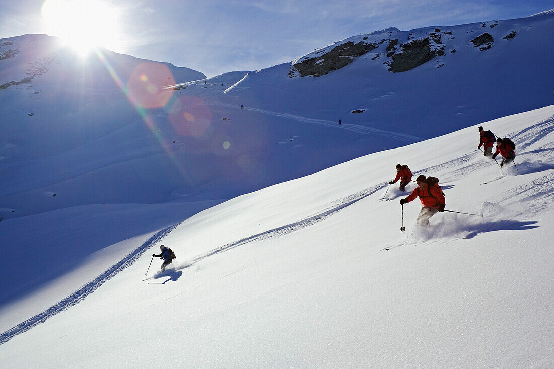 Small group of skiers descending a mountain on powder snow, Safiental, Graubuenden, Grisons, Switzerland, Alps