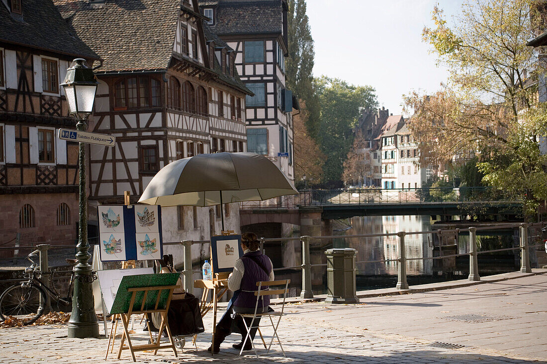 Paintress sitting at the Ill river bank at Place Benjamin Zix, Paintress sitting at the Ill river bank at Place Benjamin Zix, La Petit France Little France, , Strasbourg, Alsace, France