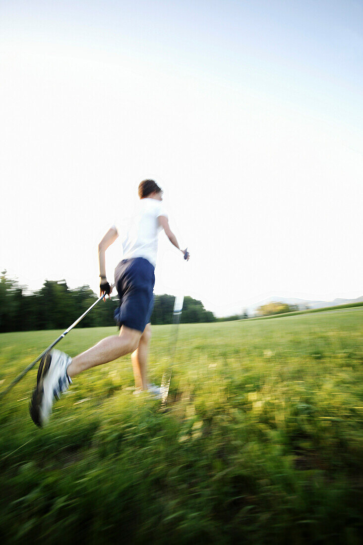 Junger Mann beim Nordic Walking