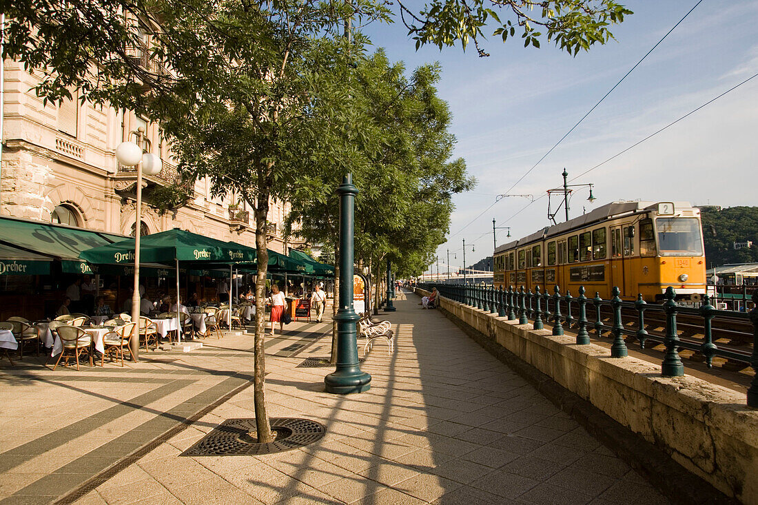 Promenade with restaurants, View along Promenade with restaurants and a tram at the right side, Pest, Budapest, Hungary