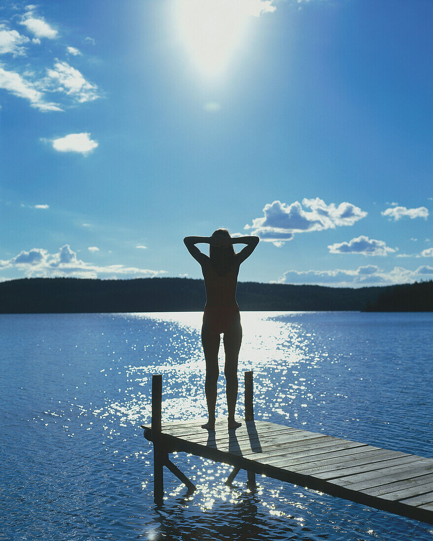 Junge Frau steht am Steg und geniesst die Aussicht