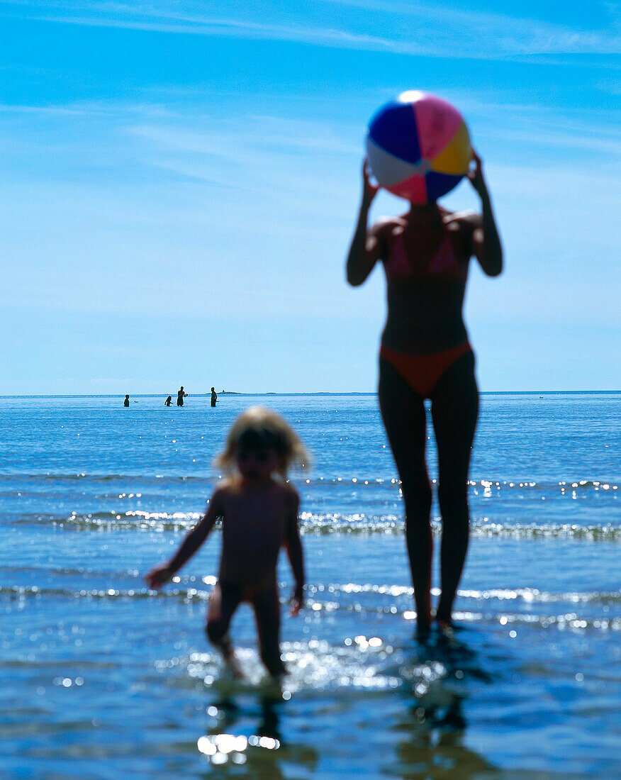 Mother and daughter playing with beach ball