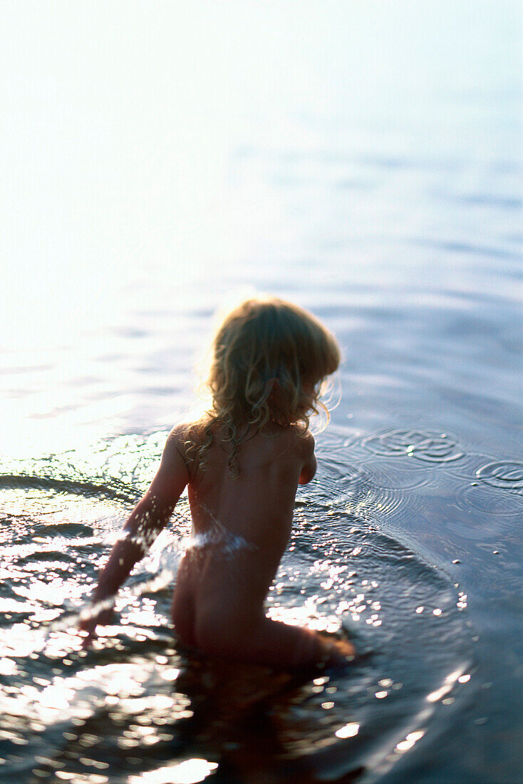 Little girl playing in lake