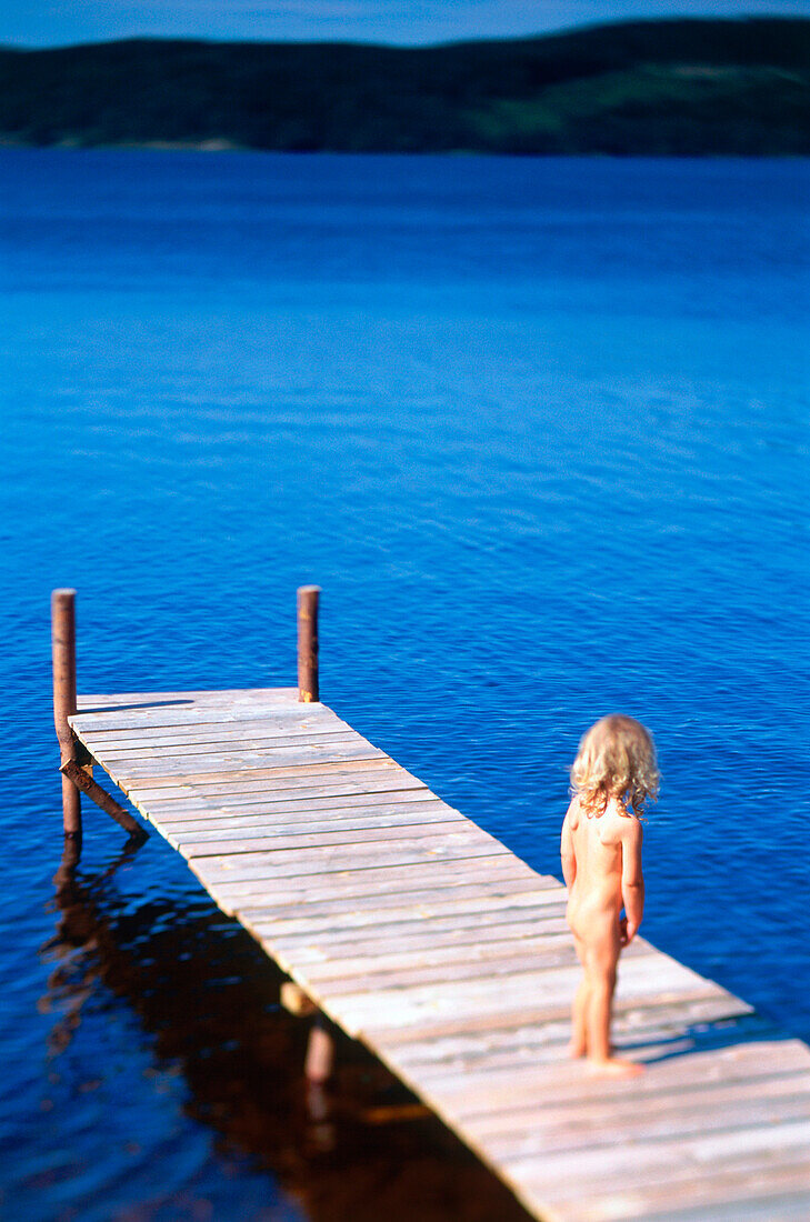 Little girl standing on a jetty
