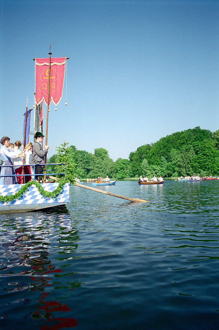 Menschen fahren während einer Prozession in Booten über den Staffelsee, Murnau, Bayern, Deutschland