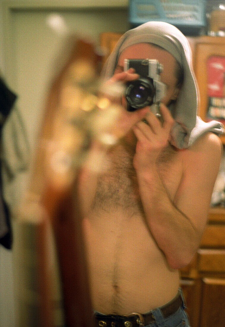 Spiegelbild eines Mannes mit Fotoapparat