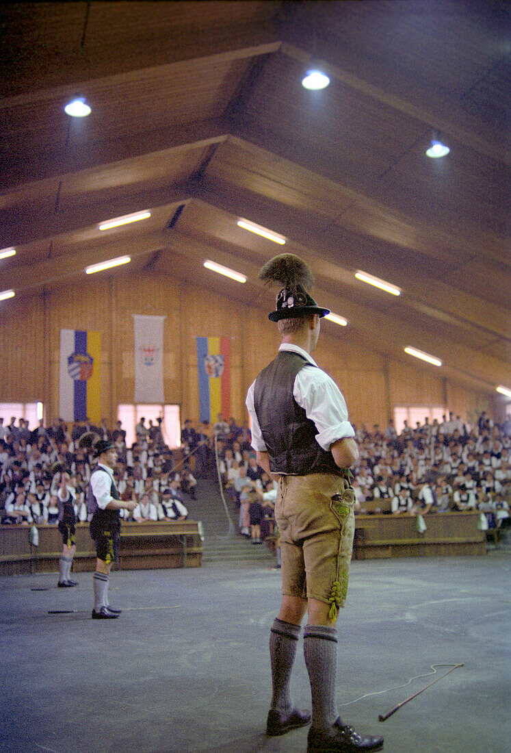 Männer in Tracht stehen bei den Bayerischen Meisterschaften im Goaslschnalzen in einer Halle, Miesbach, Bayern, Deutschland