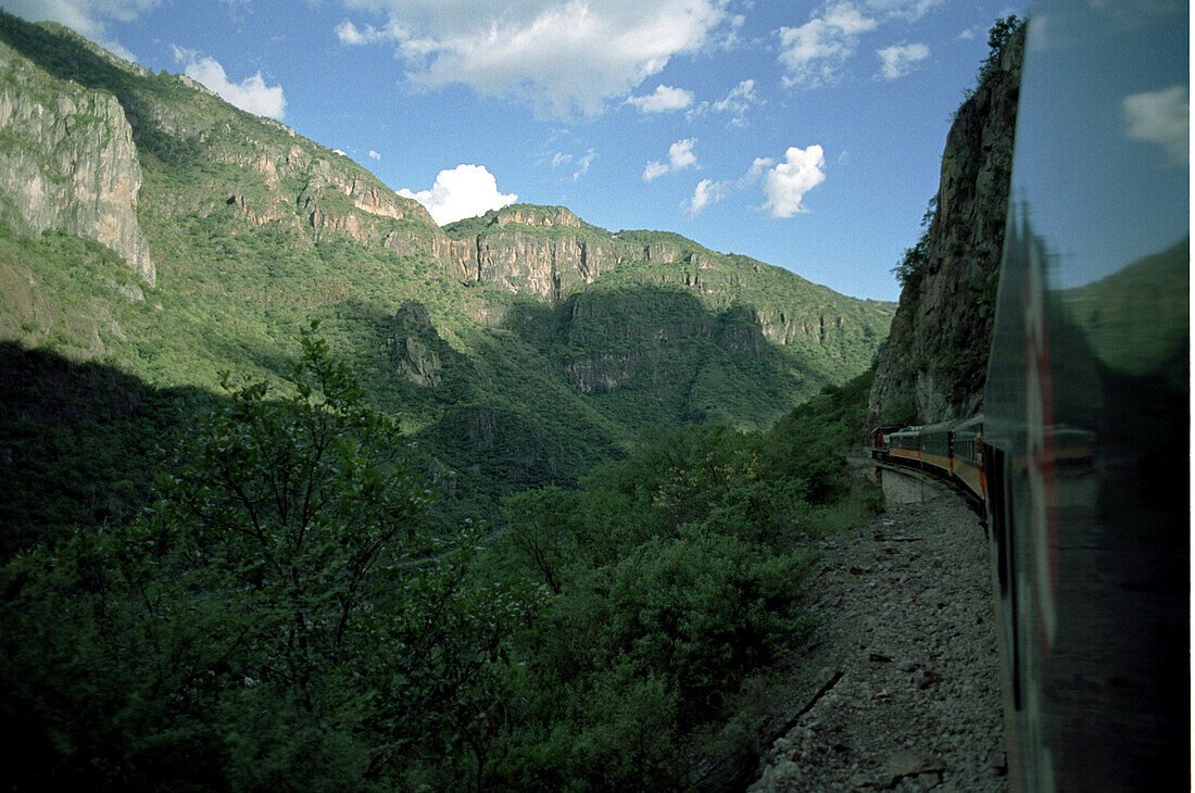 Zug fährt durch Berglandschaft, Ferrocarril Chihuahua al Pacifico, Chihuahua Express, Mexiko, Amerika