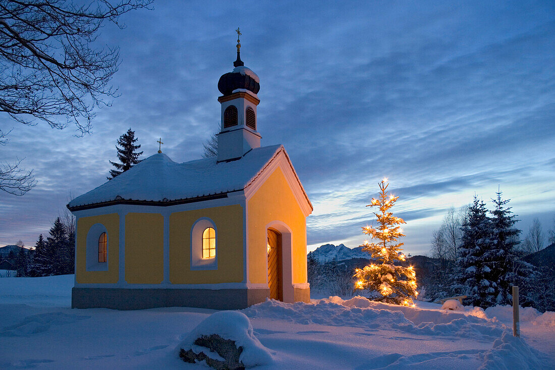 Kapelle mit Christbaum in der Dämmerung, Oberbayern, Deutschland