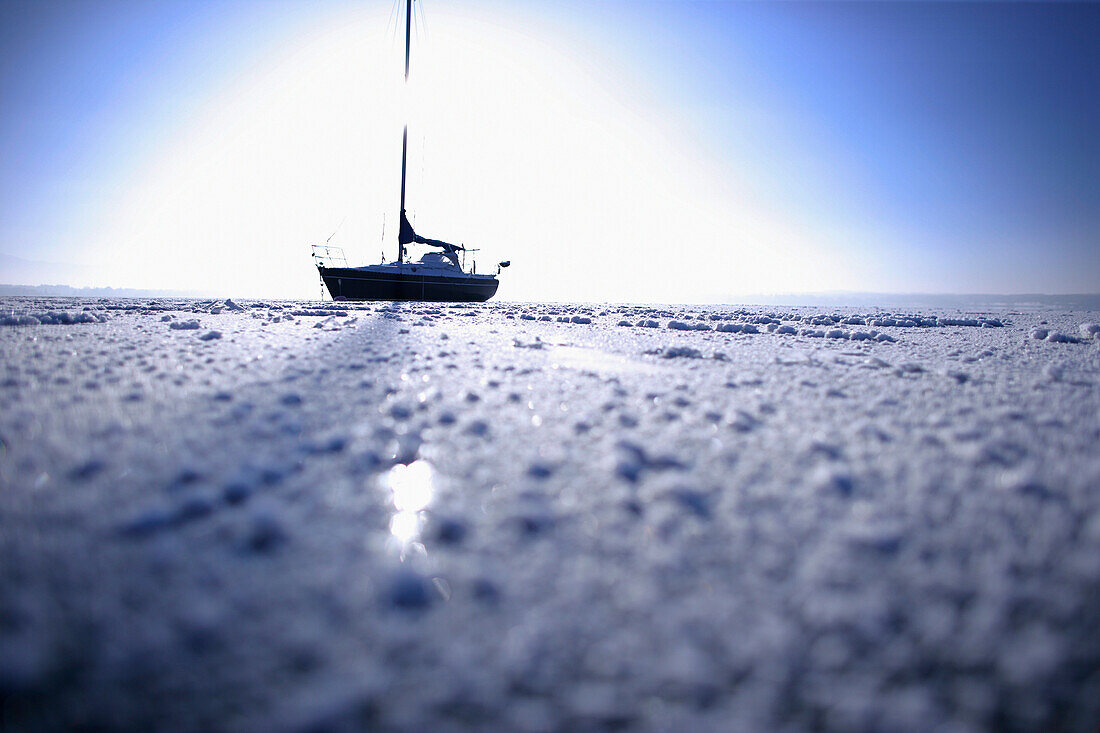 Segelboot im zugefrorenen See, Ambach, Starnberger See, Bayern, Deutschland