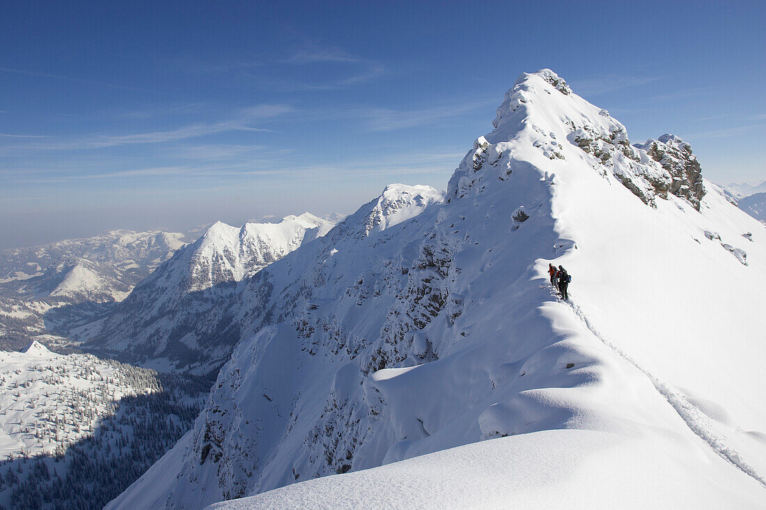 Three persons on snowcovered ridge, Nebelhorn, Oberstdorf, Bavaria, Germany