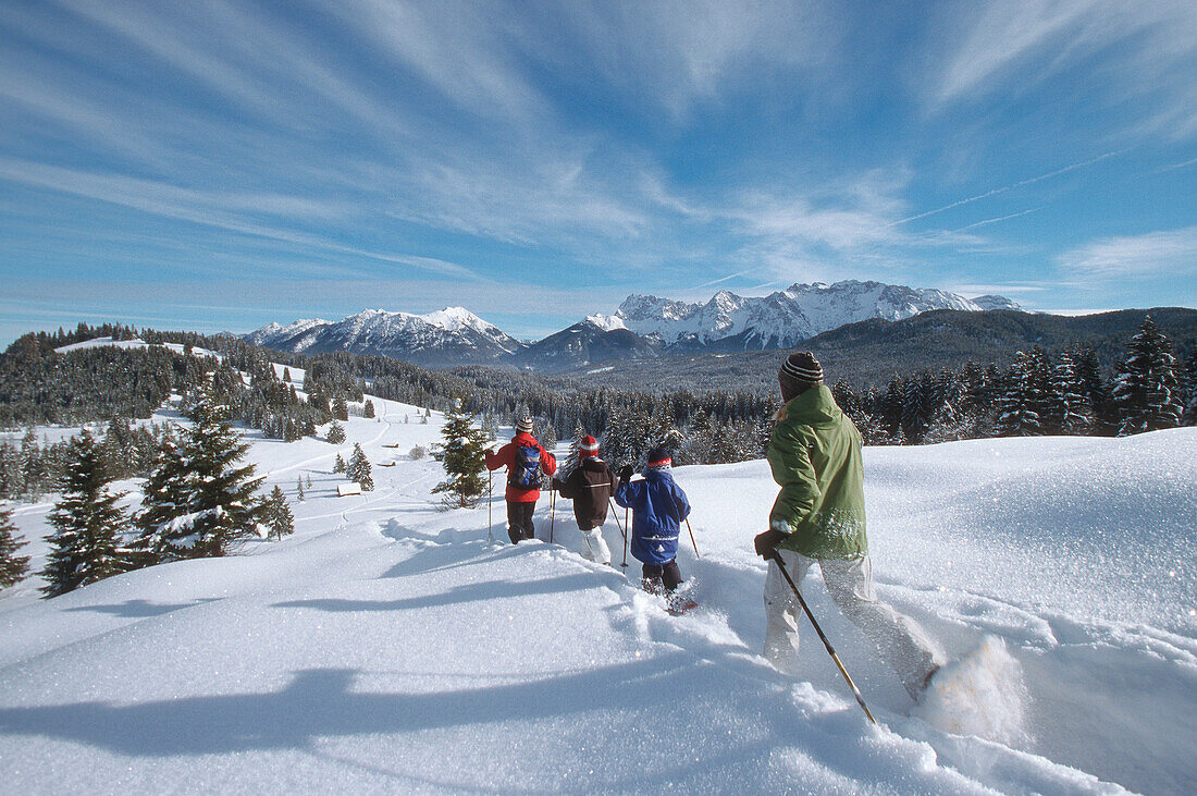 Family with two children snowshoeing, Ellmau, Garmisch-Partenkirchen, Germany