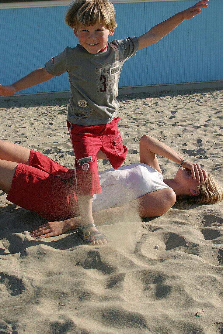 Young boy jumping over his mother, Viareggio, Italy