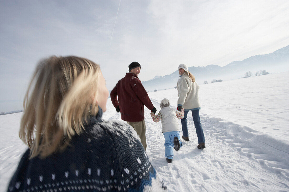 Family with two children walking on snow