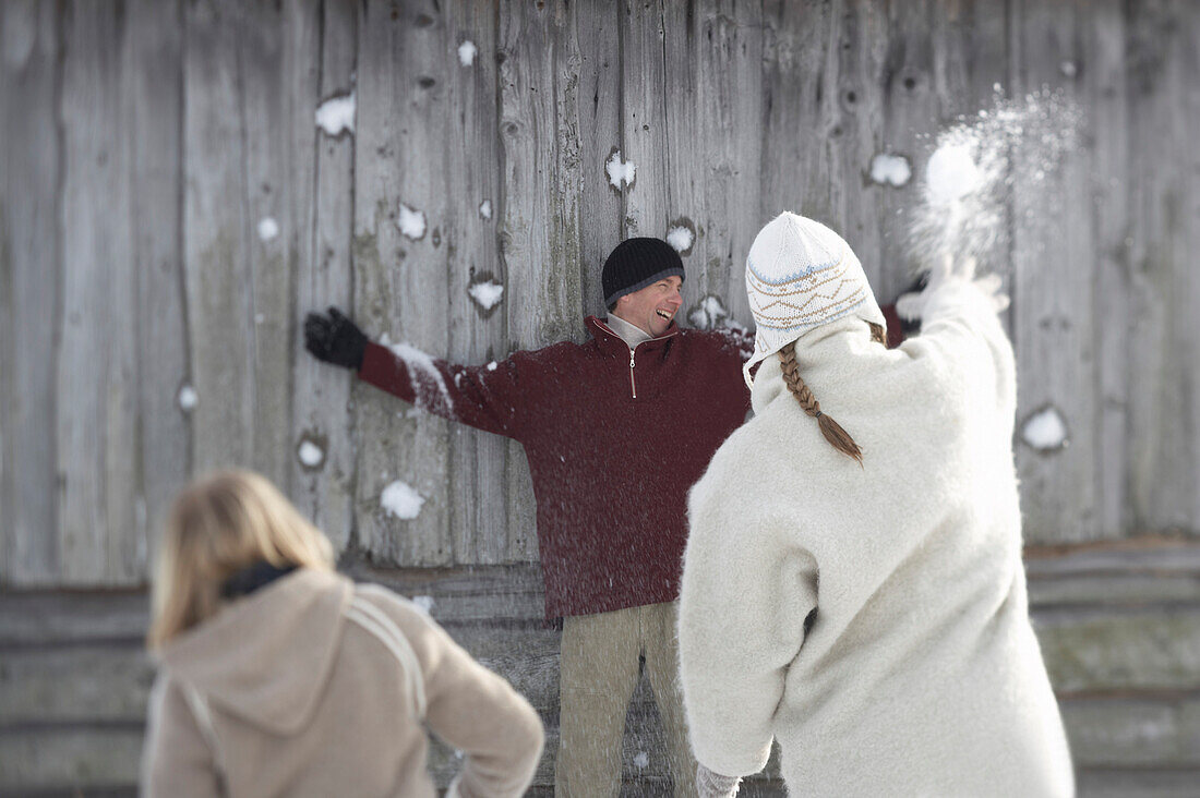 Familie bei einer Schneeballschlacht