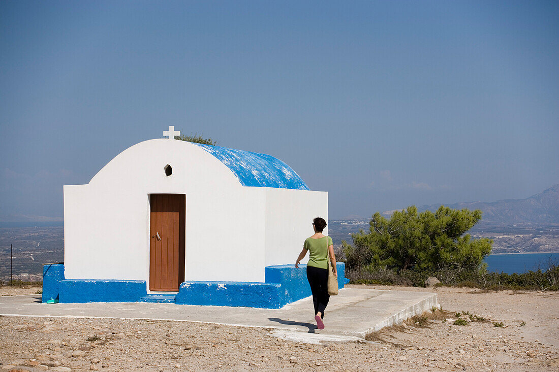 Woman visiting the capel Panagia Ziniotissa near Kefalos, Kos, Greece