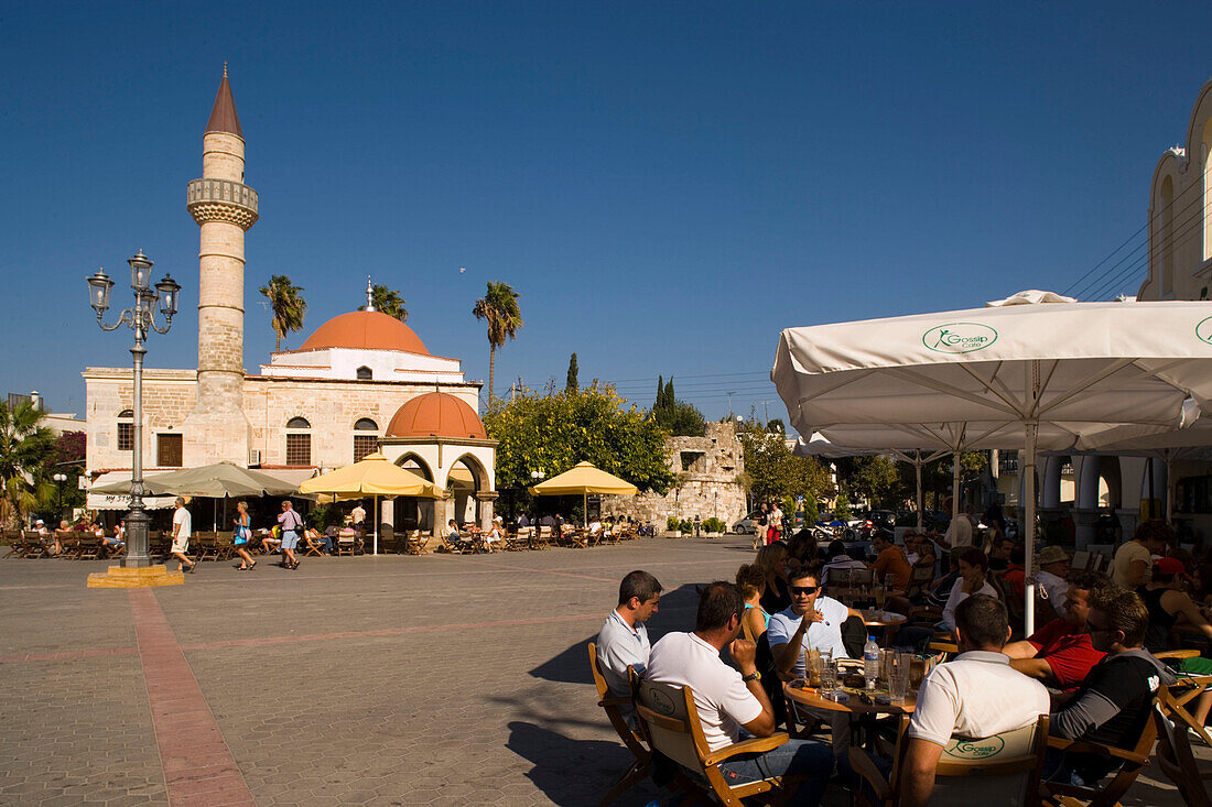 People sitting in a pavement cafe near Defterdar-Mosque at Platia Eleftherias, Kos-Town, Kos, Greece