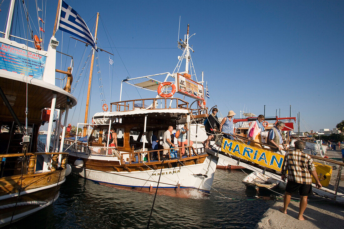 People leaving a three island excursion sailing boat at Mandraki harbour, Kos-Town, Kos, Greece
