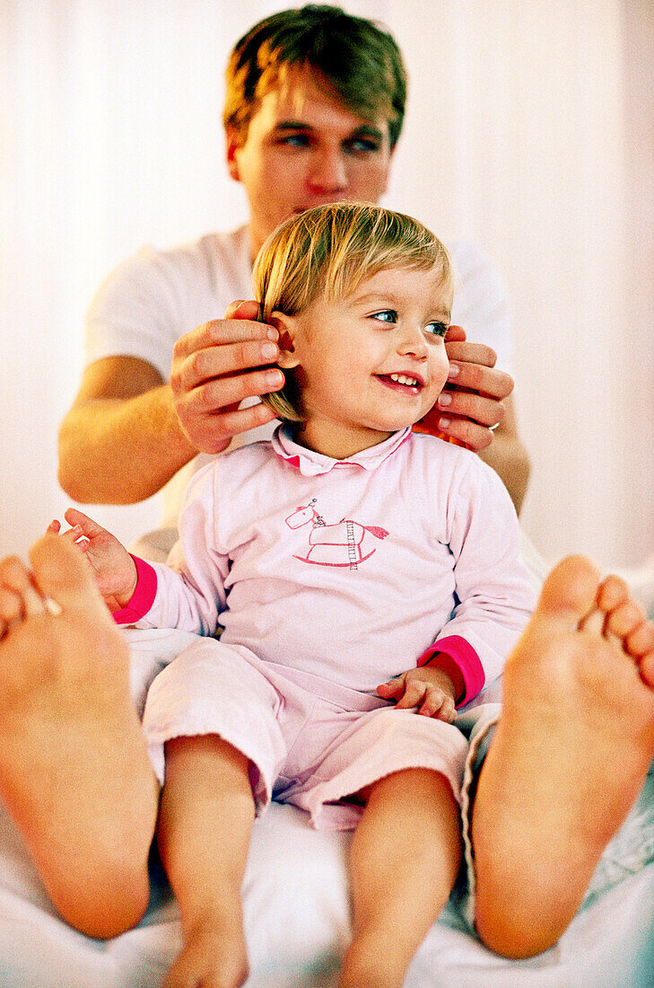 Vater und Tochter kuscheln im Bett