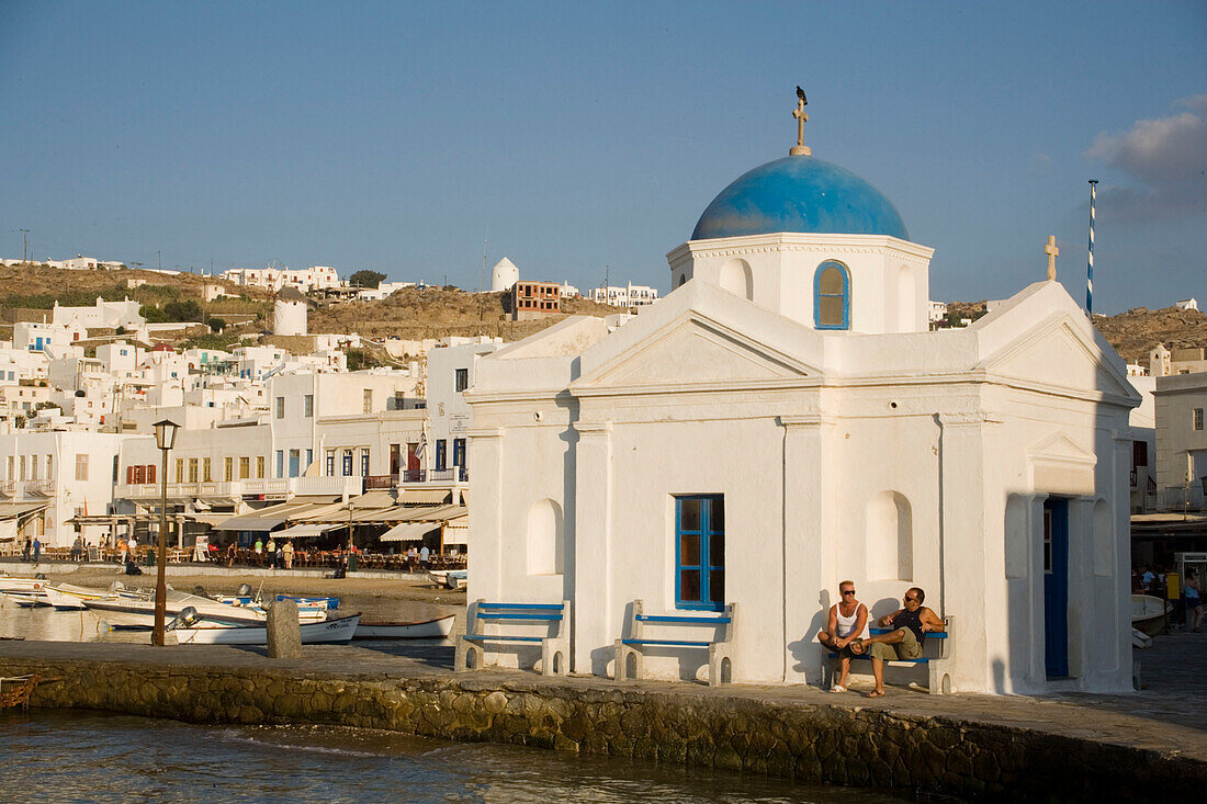 Two men sitting at a capel at harbour, Mykonos-Town, Mykonos, Greece