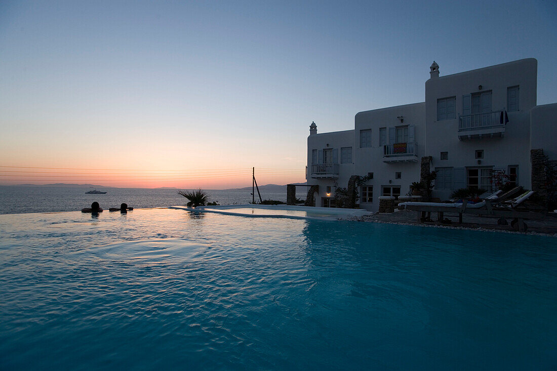 People lying in the fresh water pool and looking over the sea in the dusk, Apanema Resort Hotel, Mykonos-Town, Greece