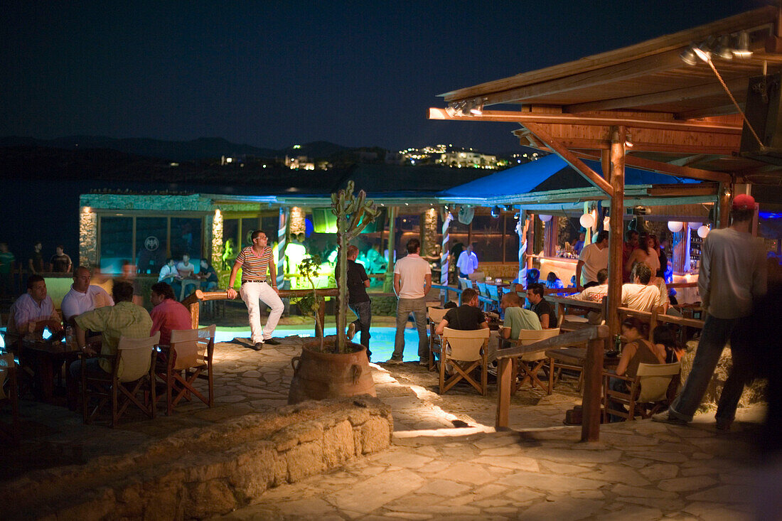 Tourists sitting in the open-air club of Cavo Paradiso, Paradise Beach, Mykonos, Greece