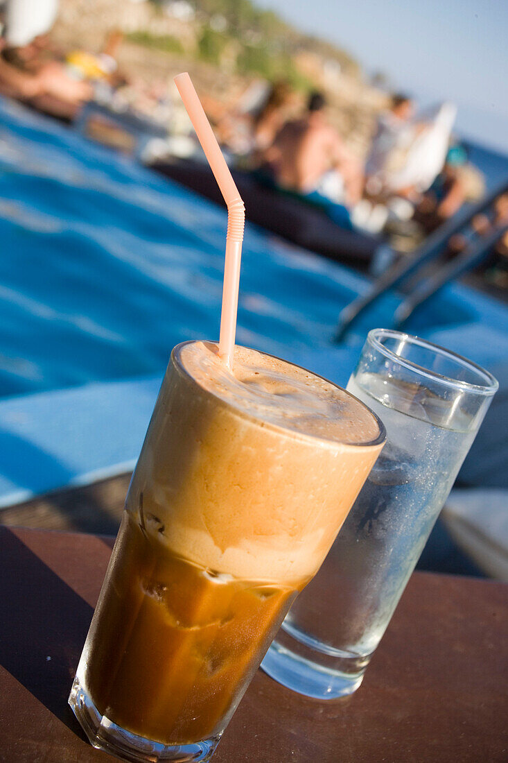 Frappè served with a glass of water in the Goya Beach Bar, the only beach bar with pool, Paranga Beach, Mykonos, Greece